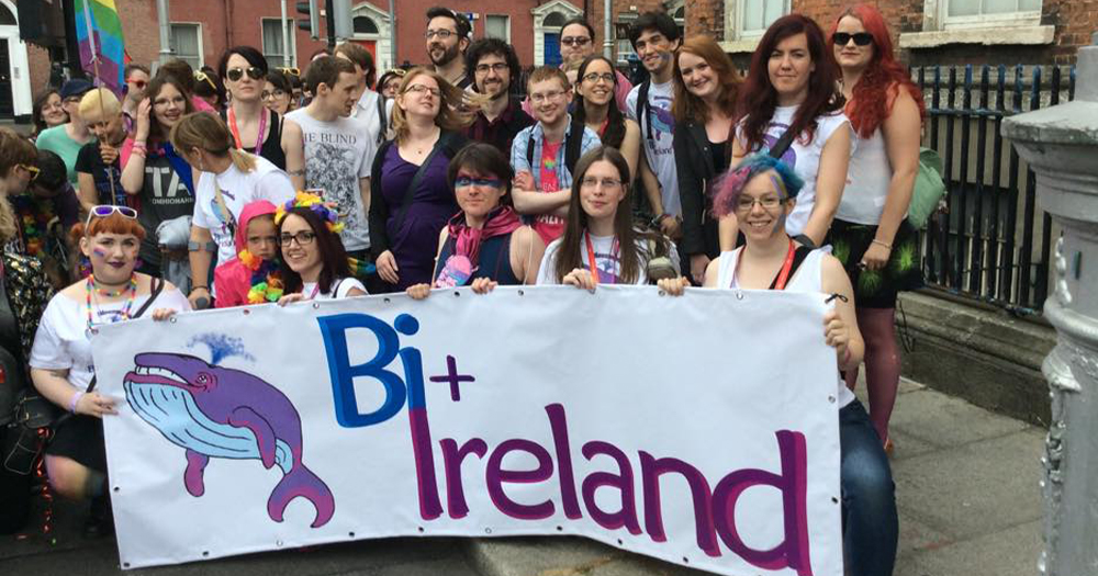 A group of people gathered around a Bi Ireland banner