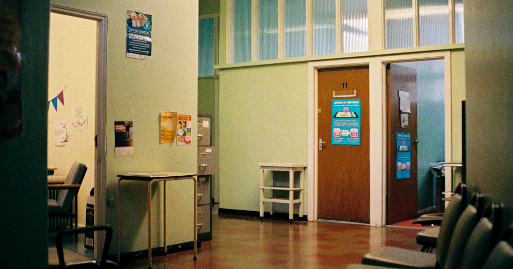 inside the GHN Baggot St waiting area a door with a poster in a hospital like corridor
