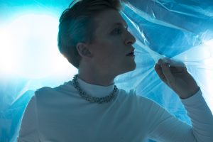 A young man lying on the ground in front of plastic sheeting