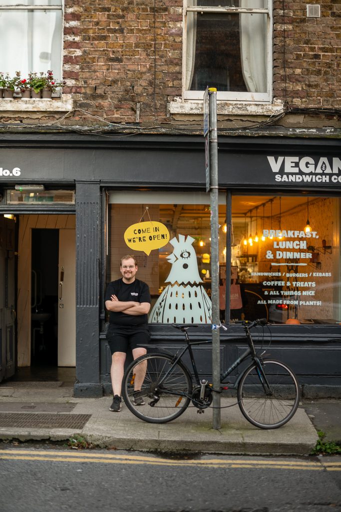 man posing outside his shop Vegan Sandwich Co