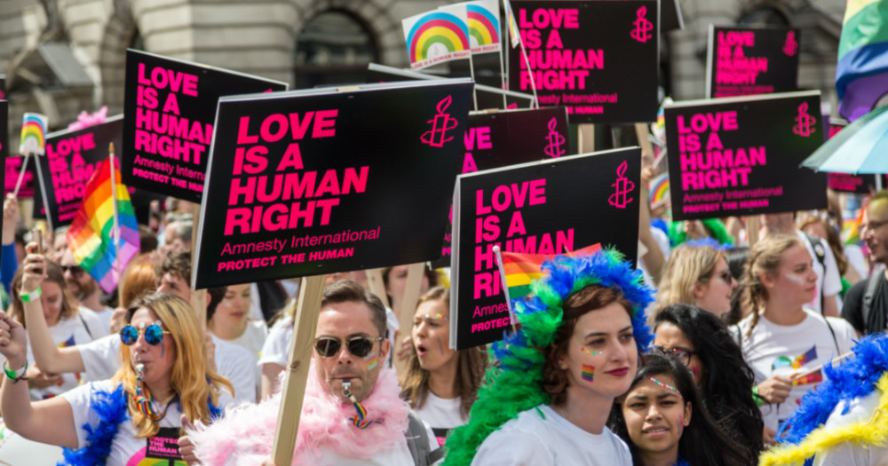 protest with signs declaring "love is a human right", homophobic hate speech rising
