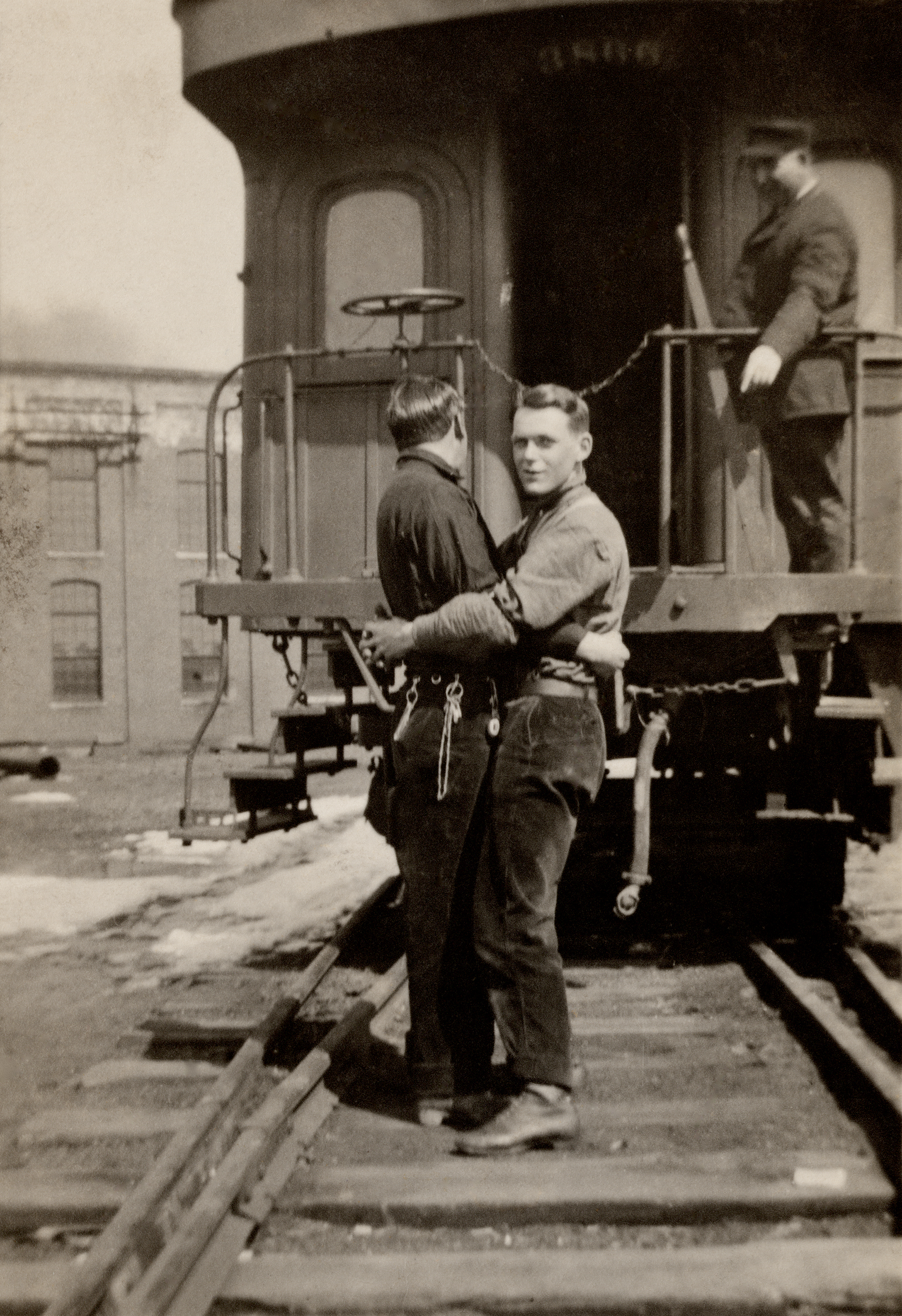 Two men hugging on train tracks, Loving, a history of men in love through photographs