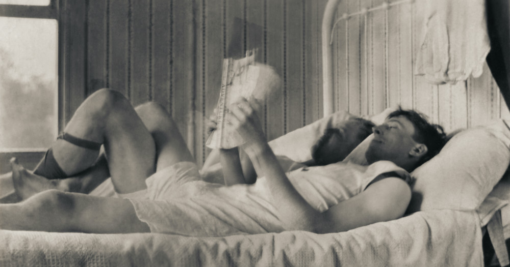Two men laying in bed, reading the newspaper, Loving men history photographs