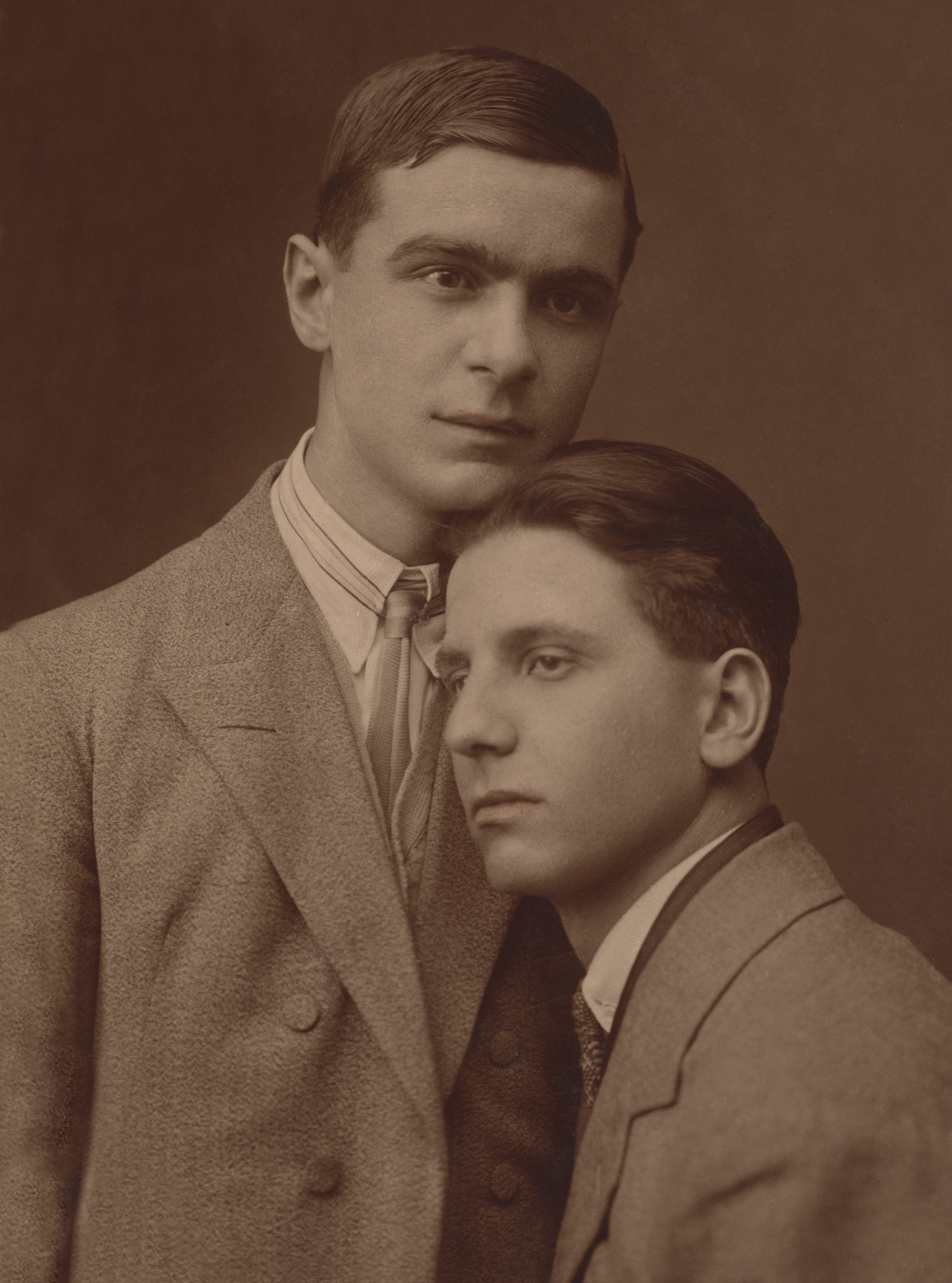 Two men leaning against each other in suits, Loving, a history of men in love through photographs