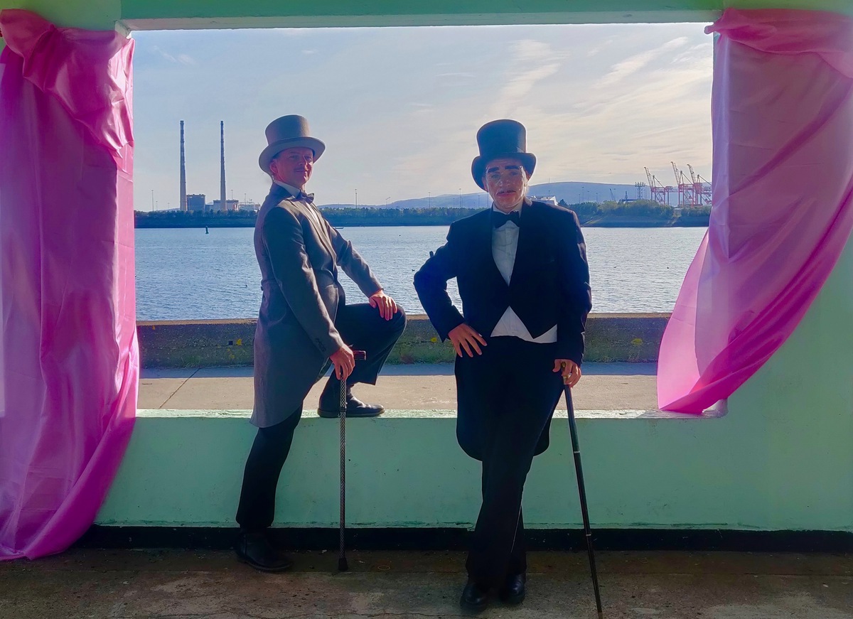 two gentlemen pose by the sea side. Piece from mash mash exhibition, queer happenings this week