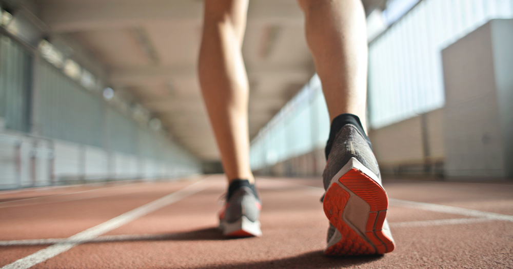 A close up of legs about to run on a track