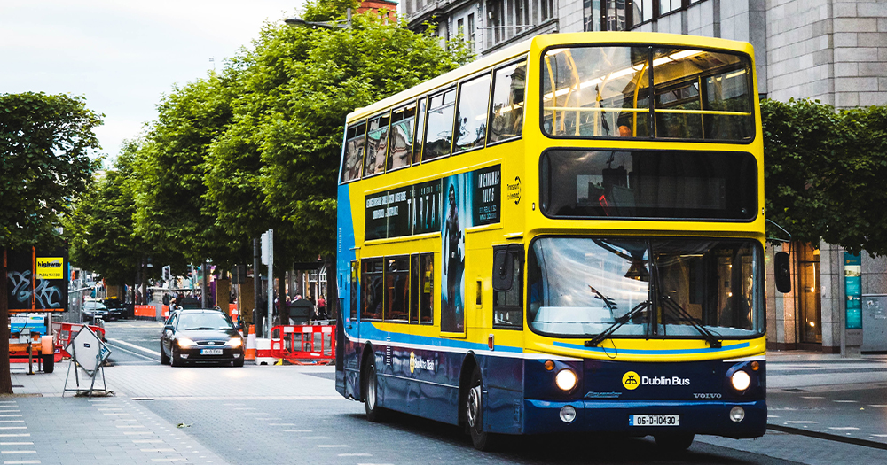 A yellow bus drives down a city street