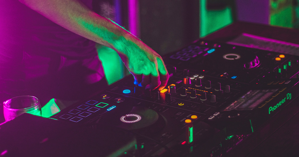 A DJ's hands at a mixing desk