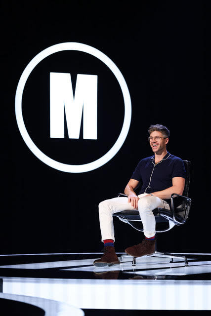 darren kennedy sitting on the black chair on the mastermind stage