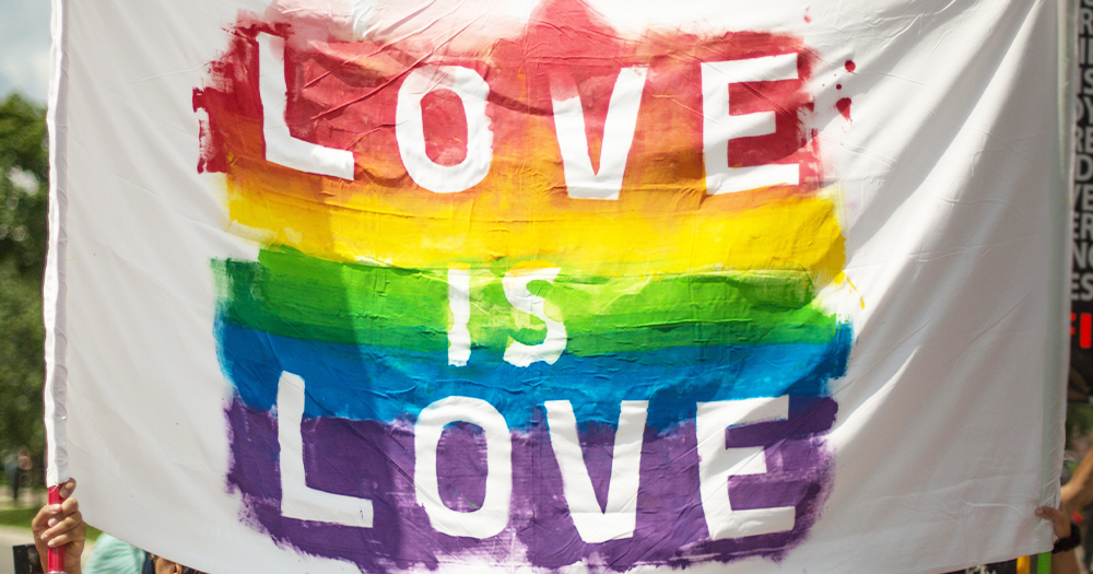 A banner reading Love Is Love in rainbow paint