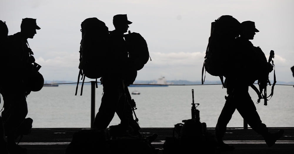 Soldiers walking by a city river