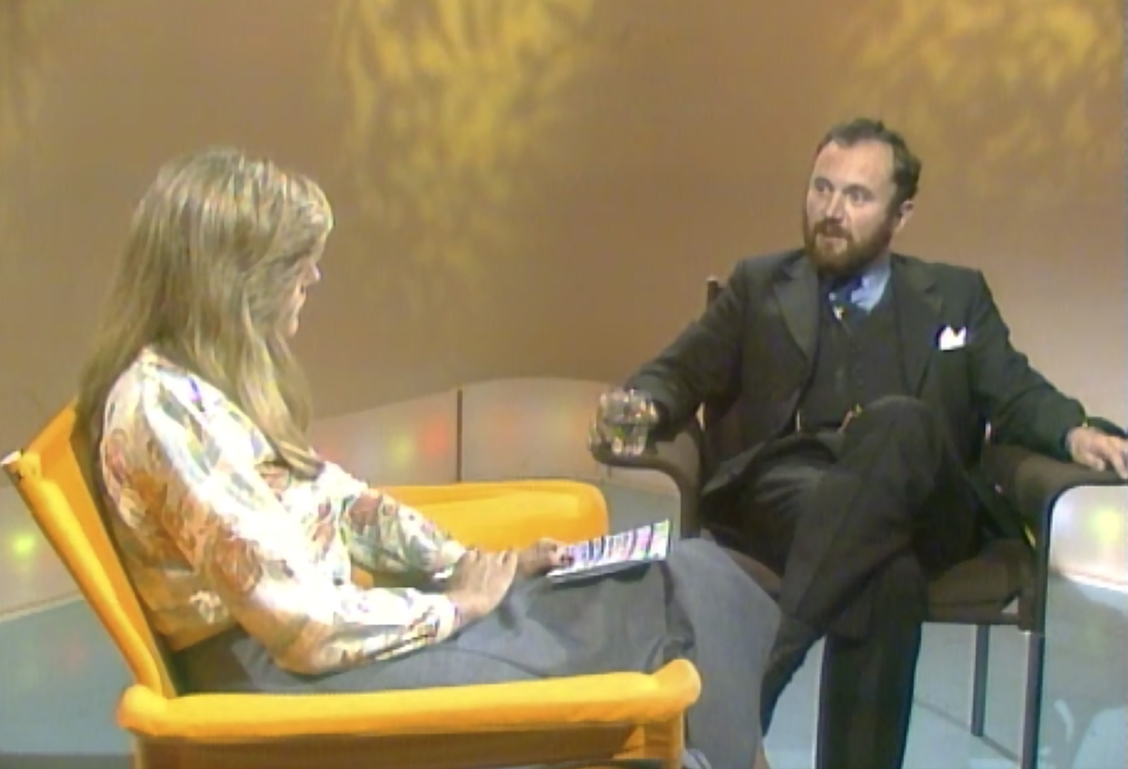 A man and woman sit in a TV studio