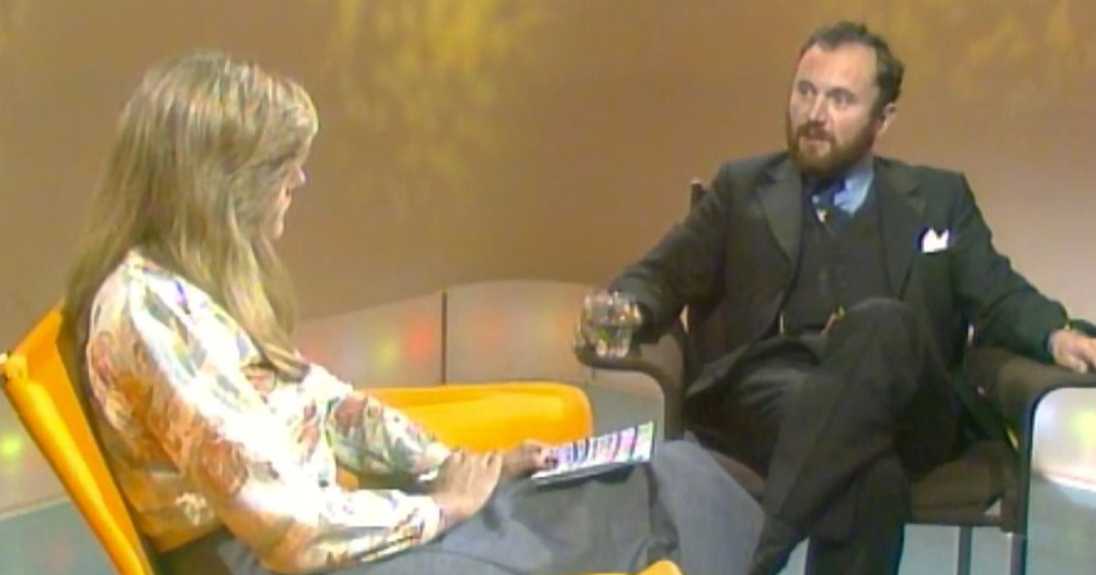 A woman and a man speaking on an old TV chat show