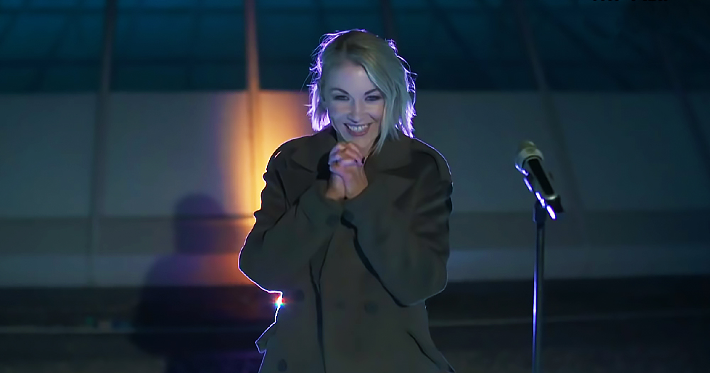 A woman outdoors at night by a microphone