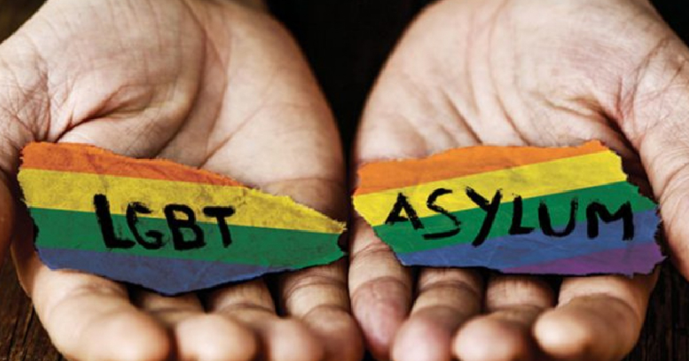 Hands painted with a rainbow coloured stripe and the words LGBT Asylum