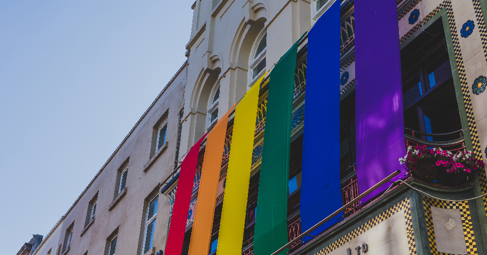 Rainbow flags hanging off the side of a building