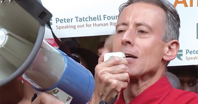 A middle aged man talking into a megaphone at a rally