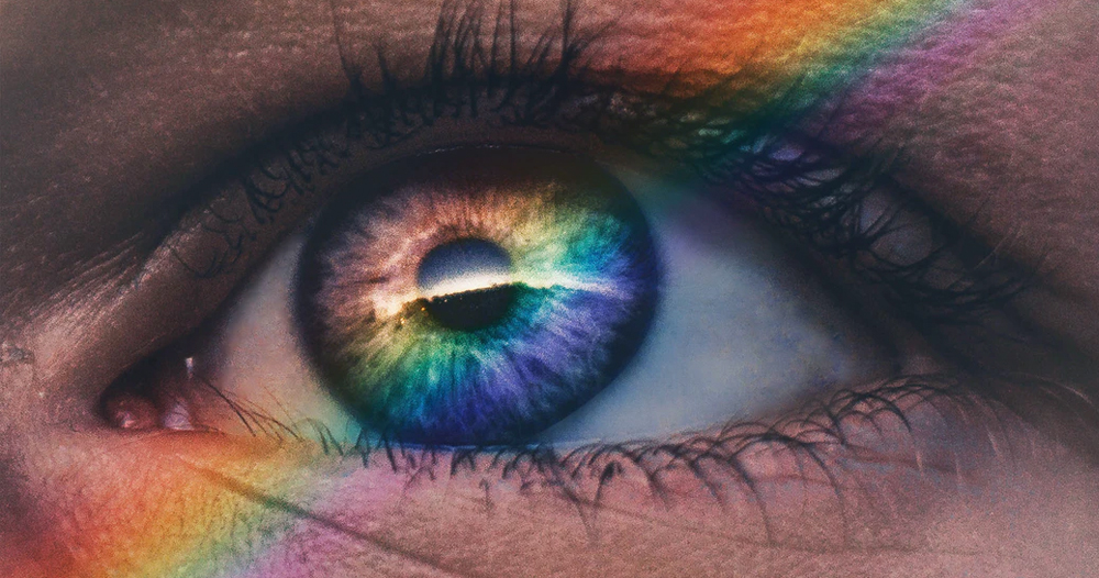 An eye with a rainbow reflected in it