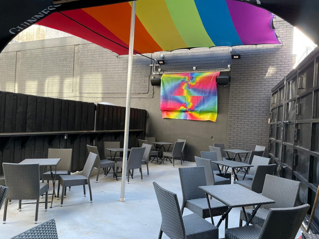 Outside sitting area of The George with bacl seats and rainbow flags. The iconic gay bar will be reopening in June.