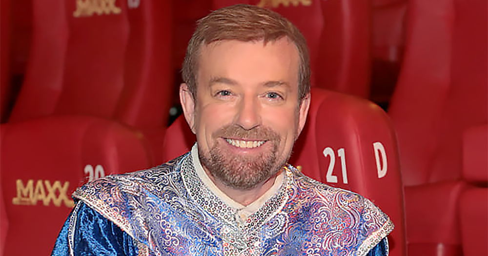 A headshot of Alan Hughes, wearing his Sammy Sausages costume, in the cinema with red seats behind him