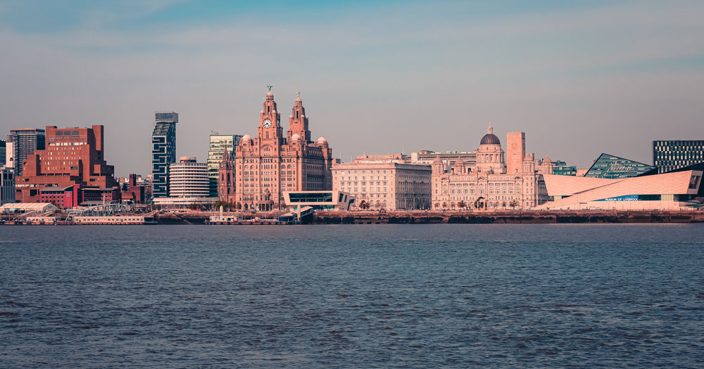 The image shows the Liverpool waterfront from the sea. A Belfast man was violently attacked in the city.