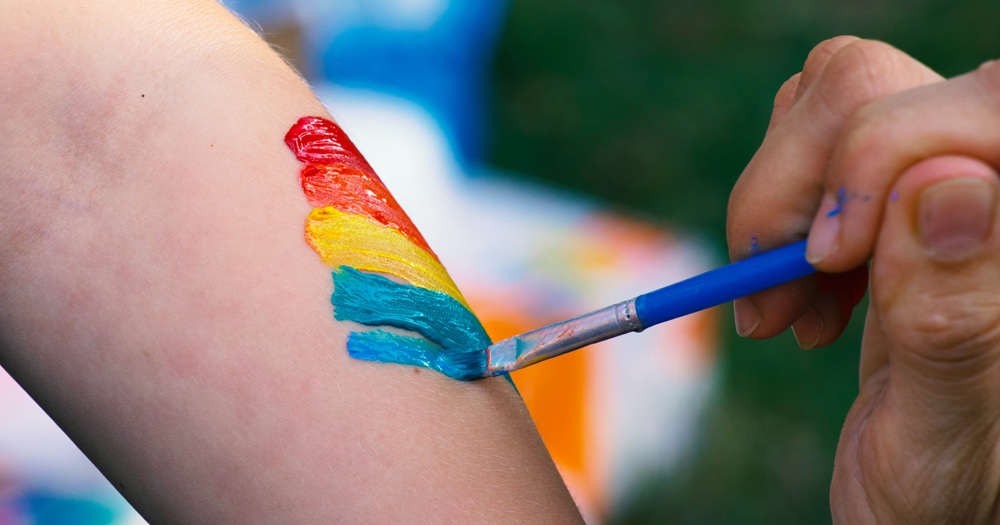 Neuro Pride will launch in August: In the photo a close up of a hand painting a rainbow on someone's arm.
