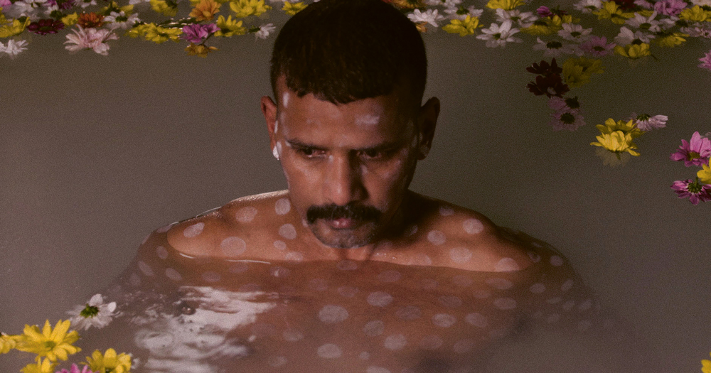 Asian man floating in water with flowers. In this piece, Pradeep Mahadeshwar talks about sexual racism