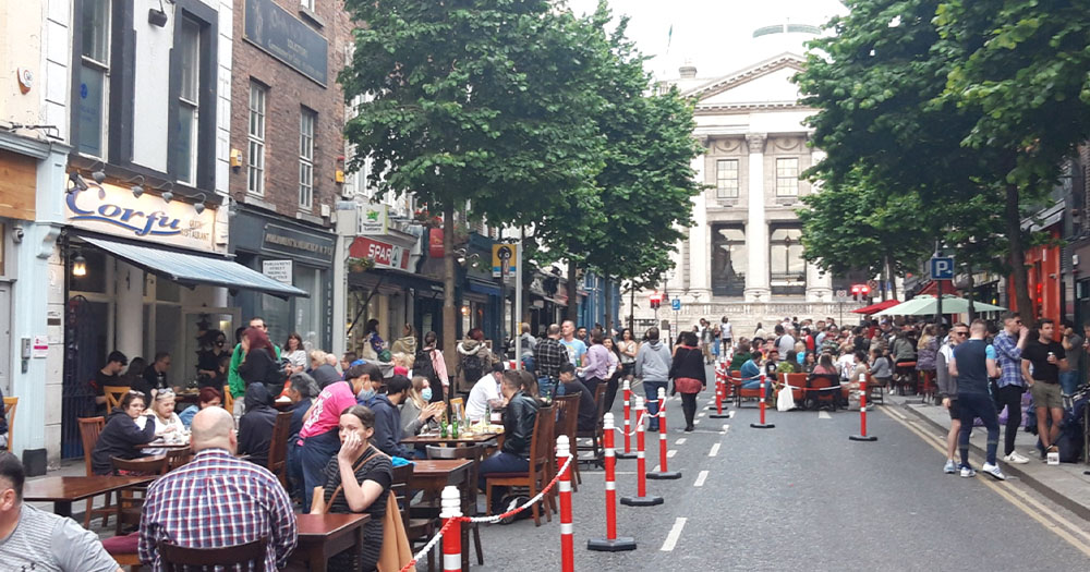 People sitting at tables on a city street