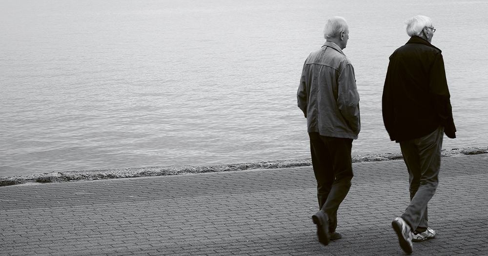 Two old men walking alongside a dock