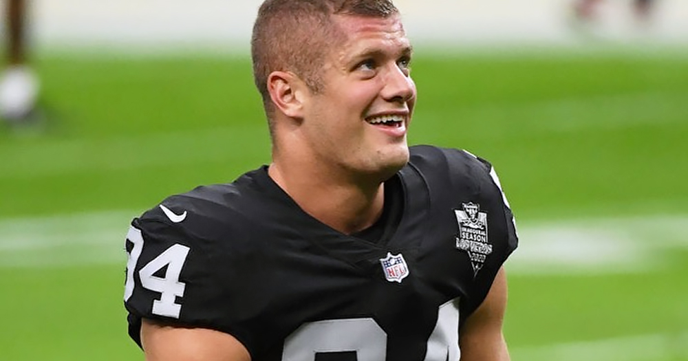 Closeup of NFL player Carl Nassib on a football field and smiling