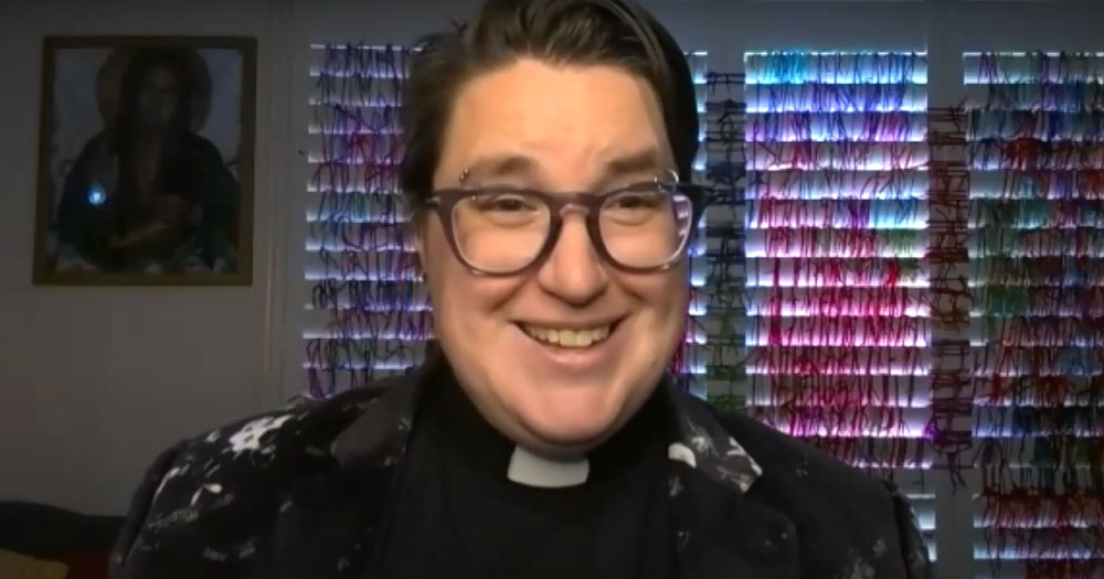ELCA's first transgender bishop, Megan Rohrer smiles in front of a colourful backdrop with a religious painting to the left