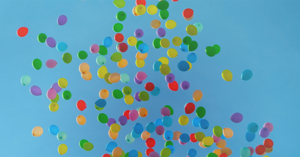 Multicoloured balloons floating away into the sky