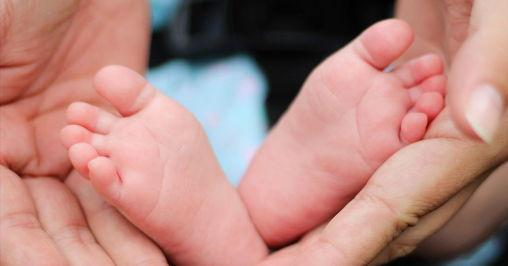 Mother and child: Close up of baby's feet and mother's hands