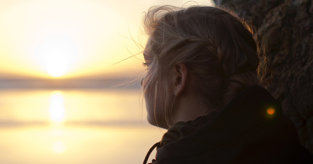 A woman looking at a sunset. In this piece, we explore the mental health services available for LGBTQ+ folks in Ireland