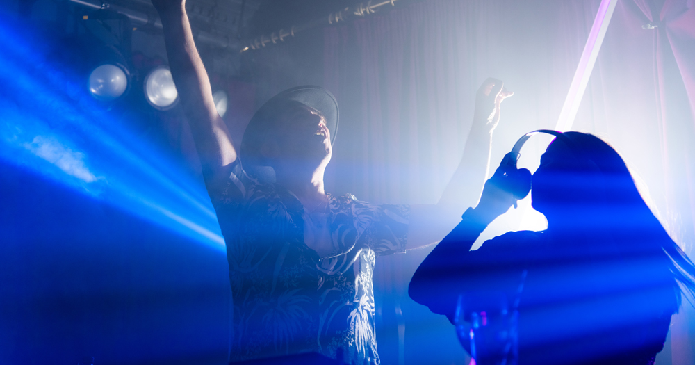 picture of Mother club DJs Rocky and Ruth bathed in stage lighting dancing to illustrate the comeback gig for opening weekend