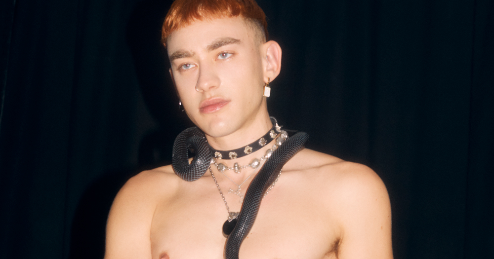 Image of Olly Alexander from Years & Years posing with a black snake for his upcoming tour press