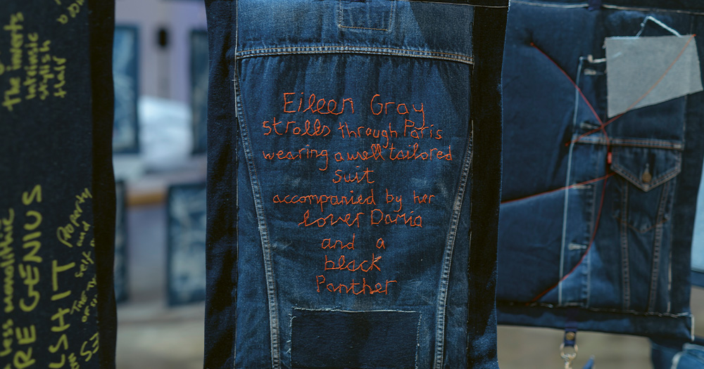 Words stitched into a hanging piece of denim fabric