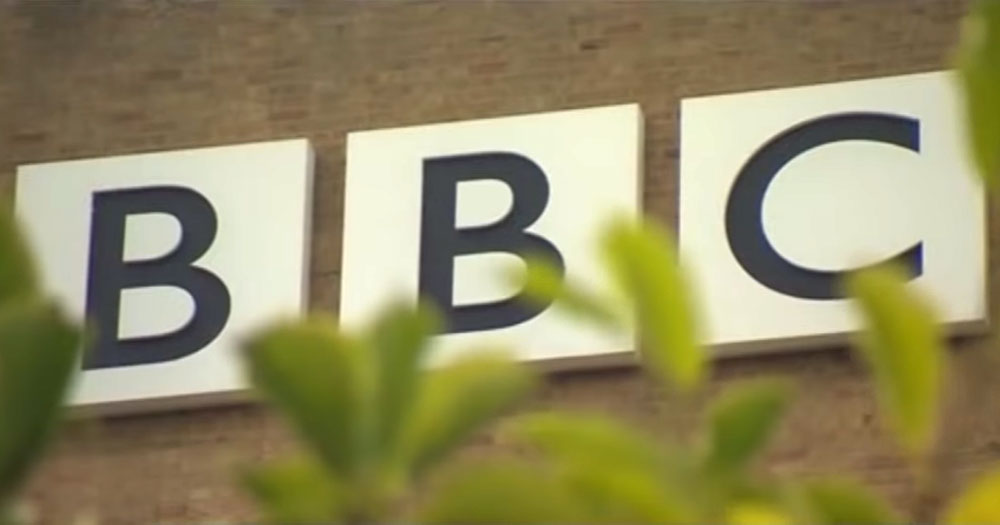 Close up of BBC building logo through shrubbery