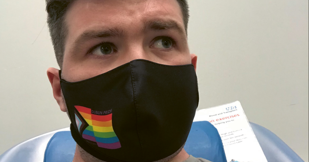 Tomás Henegan poses in the doctor's char with a face mask on as he tries to donate blood