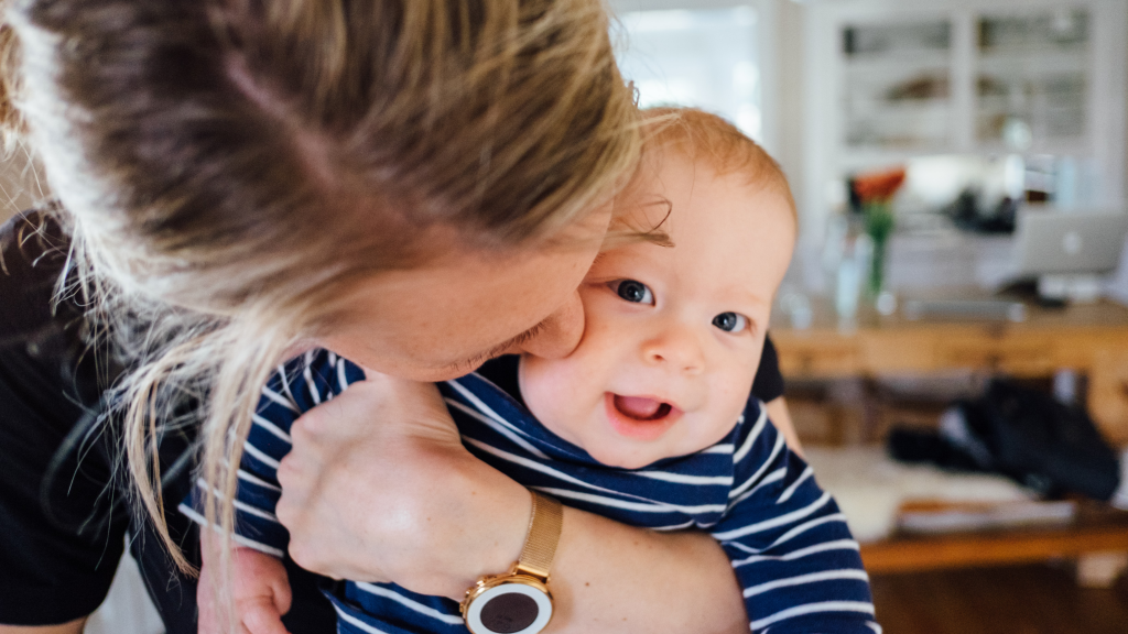 A parent lovingly holds their baby as LGBTQ+ families prepare to demonstrate at Leinster House.