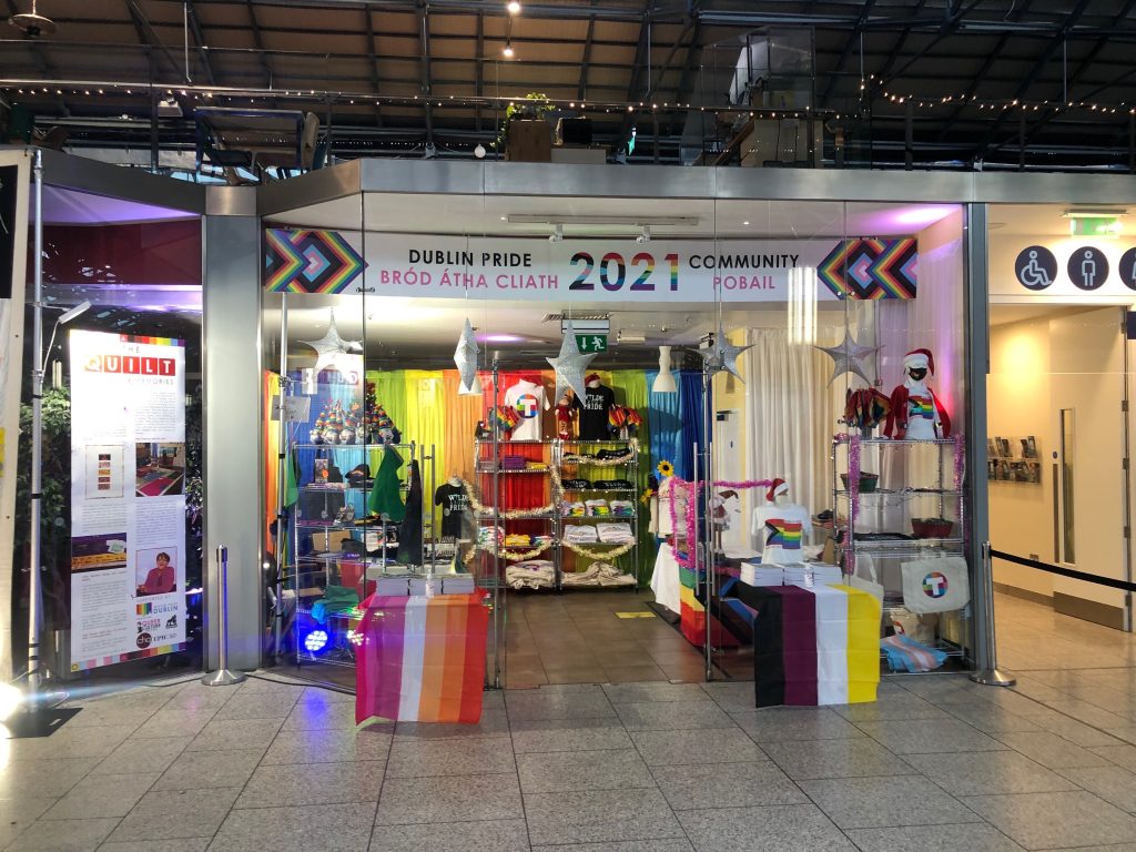 Storefront with colorful flags and clothing. This shop features projects from local Irish queer shops.