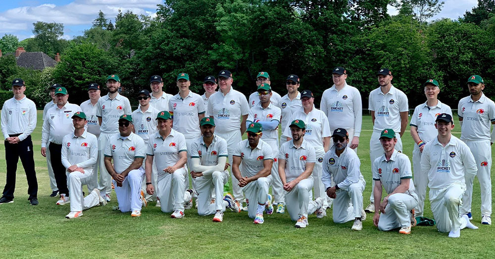 Two teams of players posing for a photo in white uniforms. This LGBTQ+ cricket match made history.