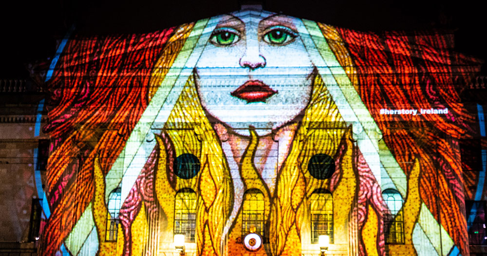 A projection of St Brigit 2022 on the side of a building