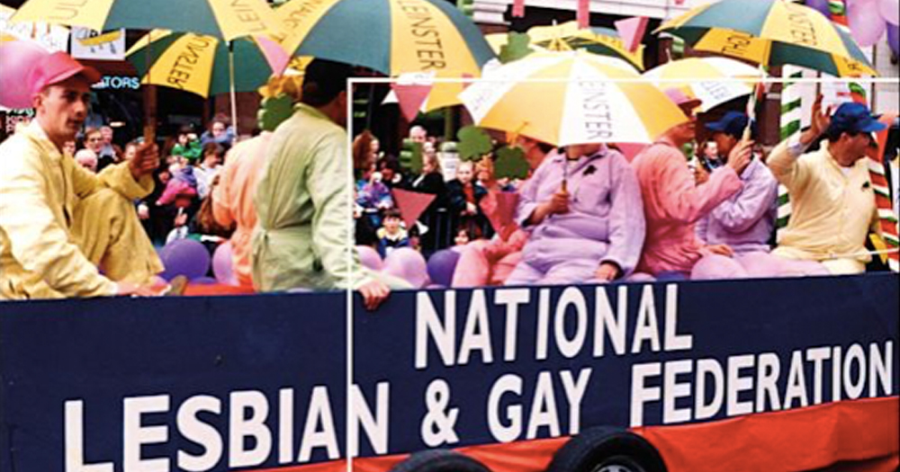 Photograph from the cover of Patrick McDonagh's book, Gay and Lesbian Activism in the Republic of Ireland, 1973 to 1993. The image is of a Pride float with people dressed colourfully, holding yellow and green umbrellas. The side of the float reads National Lesbian and Gay Federation.