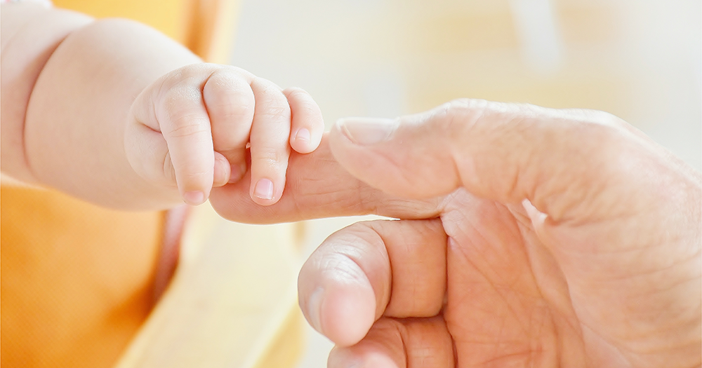 A baby holds a parent's finger as a new Oireachtas committee on surrogacy is established.