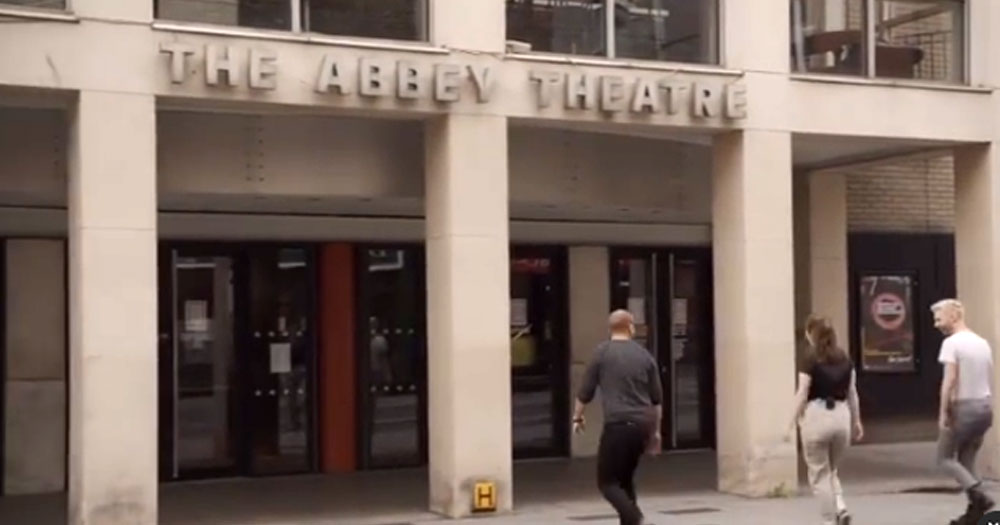 Three people walking into the Abbey Theatre building