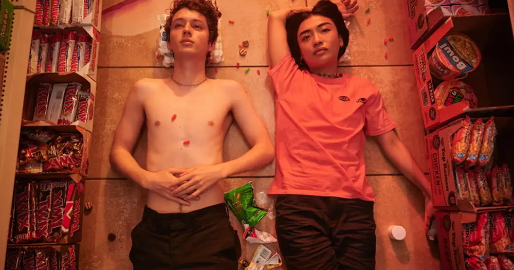 Two young people lying on a messy shop floor