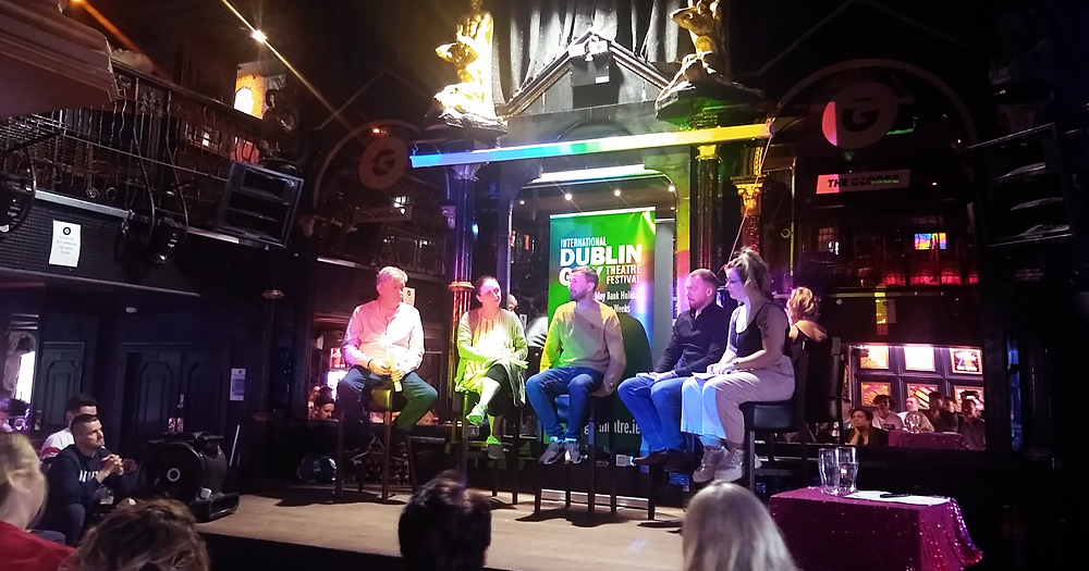 Five people talking on a stage in front of an audience at the Dublin Gay Theatre Festival, which will return in 2022.