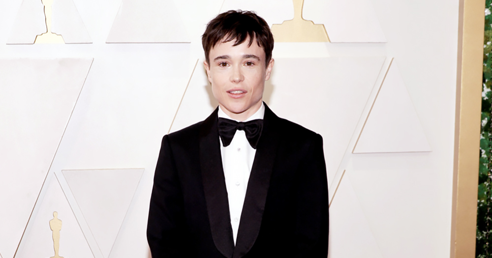 Elliot Page on the red carpet of the Oscars. He is wearing a black tuxedo with a black bowtie.