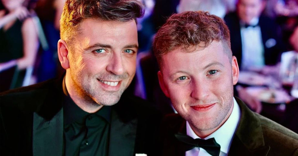 Photograph of photo of Mark Feehily (left) and his fiancé Cailean O'Neill (right) at the Burberry British Diversity Awards. Both men are wearing formal dress.